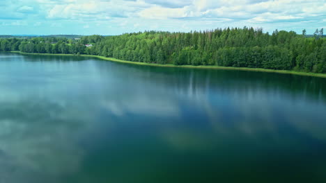 Un-Suave-Plano-Inverso-De-Un-Lago-Vecino-A-Un-Paisaje-Verde