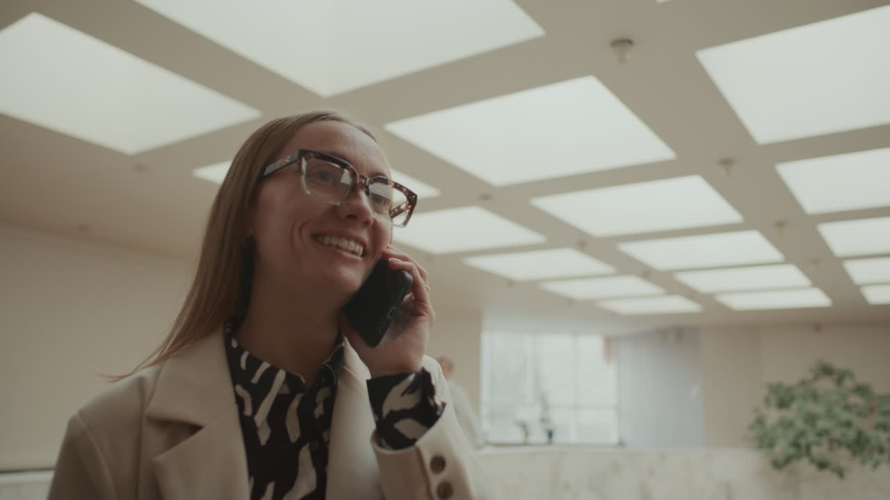 Businesswoman Having Conversation on Mobile Phone in Office