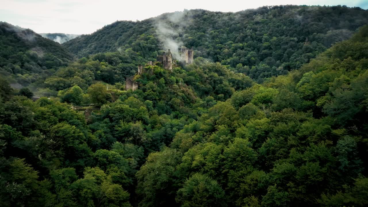 slow drone approach to a ruined castle in a mysterious forest