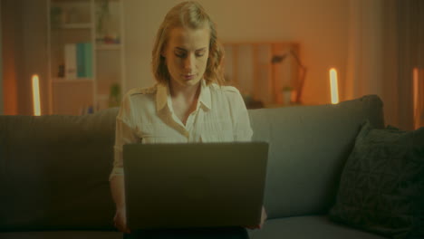 woman opens laptop and starts working at home in evening