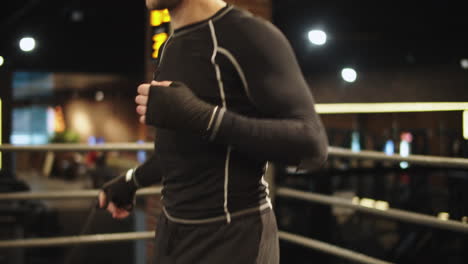 Active-sport-man-using-skipping-rope-at-gym.-Boxer-doing-exercises-on-ring