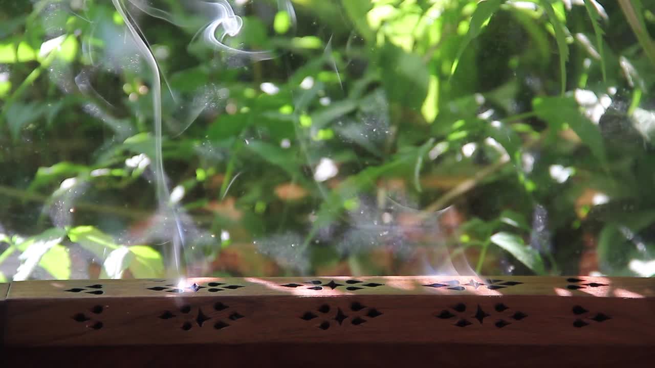 el tiempo retrocede mientras el humo del incienso se enrolla en un quemador de incienso de madera con vegetación 1