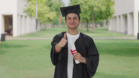 feliz estudiante universitario indio mostrando los pulgares hacia arriba
