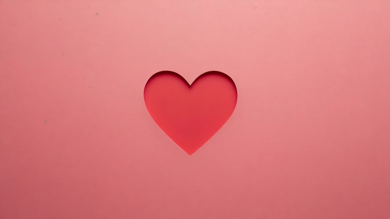 Cuore a due strati ritagliato in carta che pulsa ed espande su un set da studio, il cambio di luce rivela il supporto più scuro