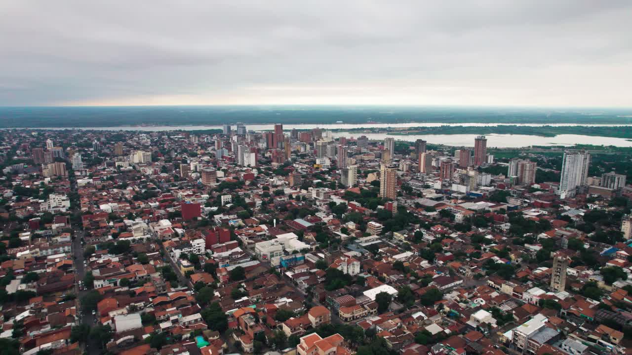 Questa foto aerea cattura Asunción, Paraguay, rivelandone la disposizione urbana con edifici e strade. Lo skyline è visibile e il paesaggio include un fiume sullo sfondo.
