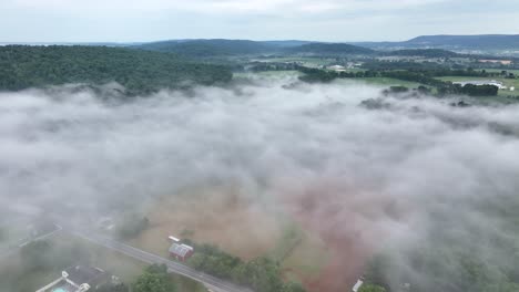 a beautiful aerial view of the fog covered landscape in the early morning light