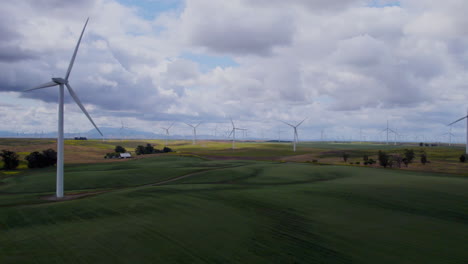 4k slow motion aerial footage of windmills over agricultural land in california
