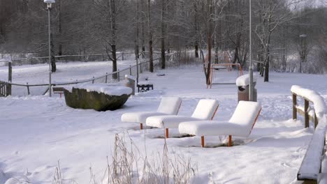 public sunbed chairs in desolated city park during winter, sweden