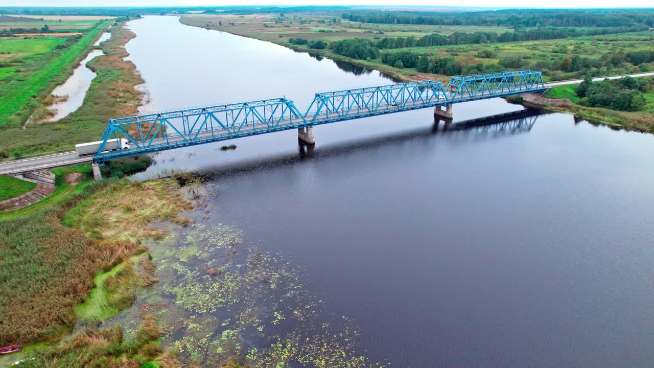 Vista aerea di un ponte blu su un fiume calmo in Lettonia