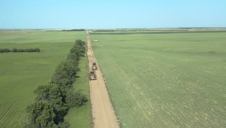 aerial view of road graders at the rough road in canadian province of saskatchewan