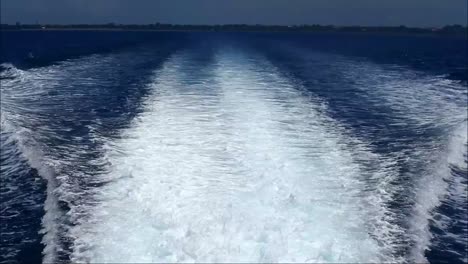 vista de las olas del océano detrás de un barco de vela que va a la isla de nusa penida, bali