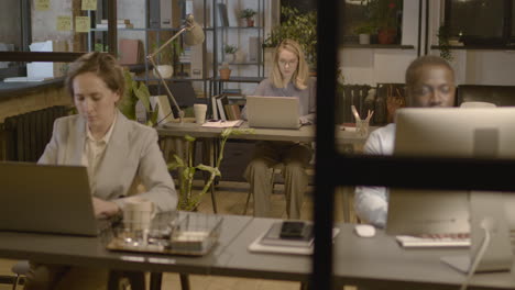 american man and women employees working on computer sitting at desk in the office 1