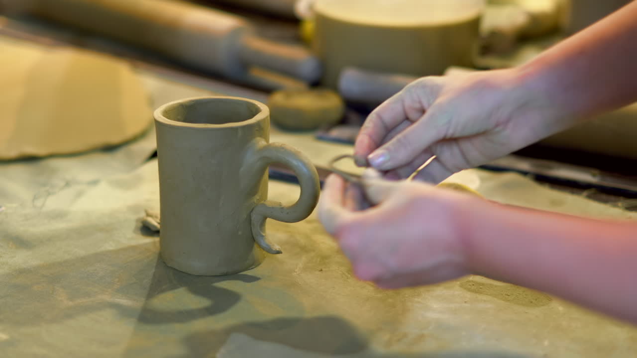 Alumnos modelando tazas con arcilla