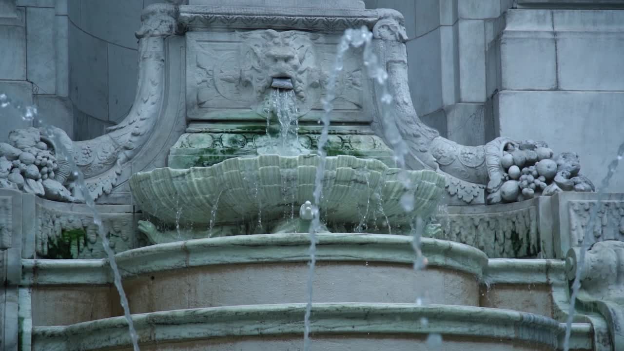 Marble lion fountain expelling water in slow motion. New York City Public Library