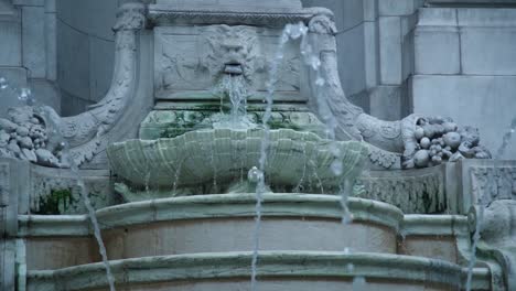 marble lion fountain expelling water in slow motion. new york city public library