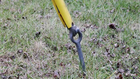 Shot-of-a-moving-ground-guy-wire-anchor-connecting-to-a-distribution-pole-moving-in-the-wind-and-yellow-visibility-cover