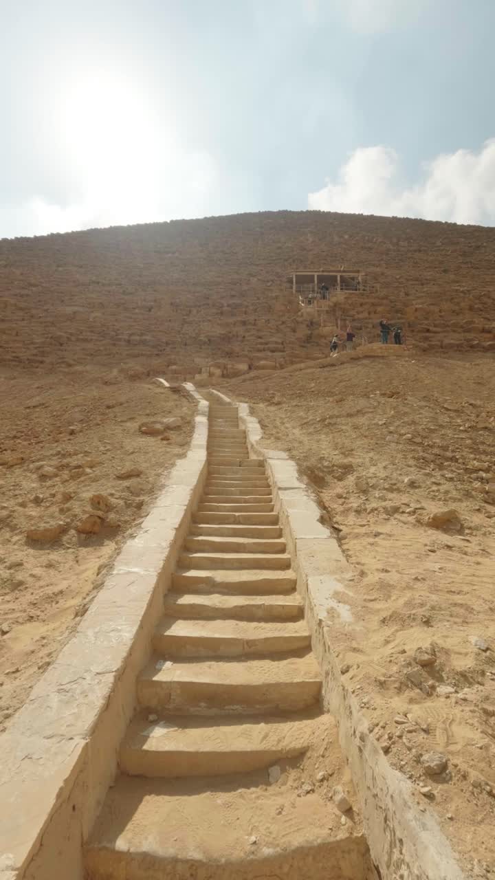 Lang steintrapp som fører opp en sandbakke i det gamle Egypt