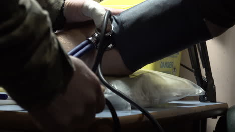 a military doctor tests the blood pressure of a ukrainian soldier who is suffering concussion at a frontline stabilisation point field hospital at an undisclosed location.
