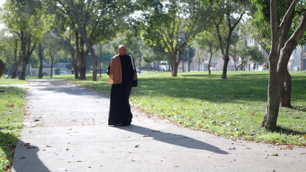 Woman in Hijab and Abaya Walking in a Park
