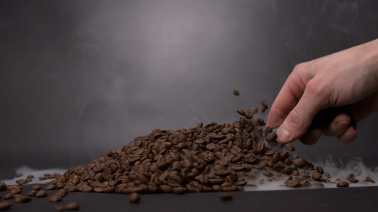 scooping coffee beans with smoke everywhere in super slow motion