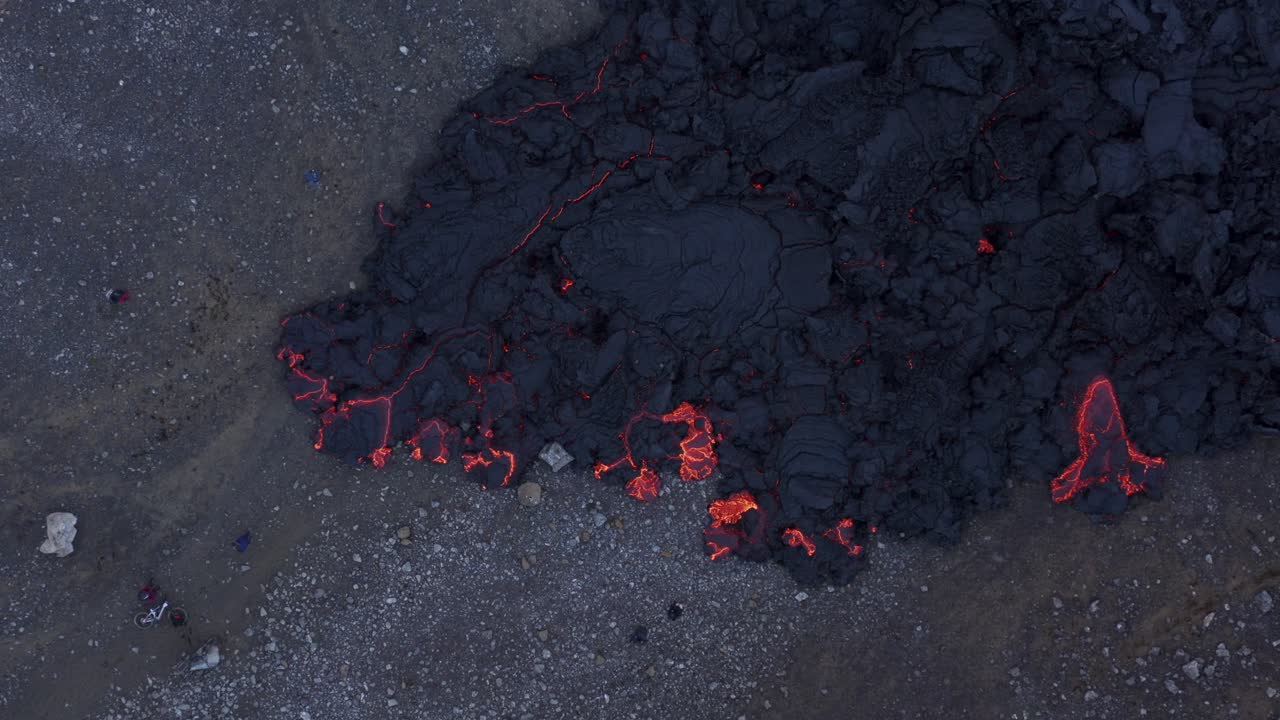 Ripresa dall'alto di turisti locali in piedi vicino a un campo di lava calda e lenta