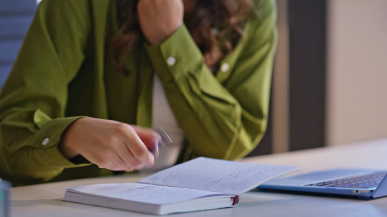 Una donna che parla al telefono e scrive su un quaderno