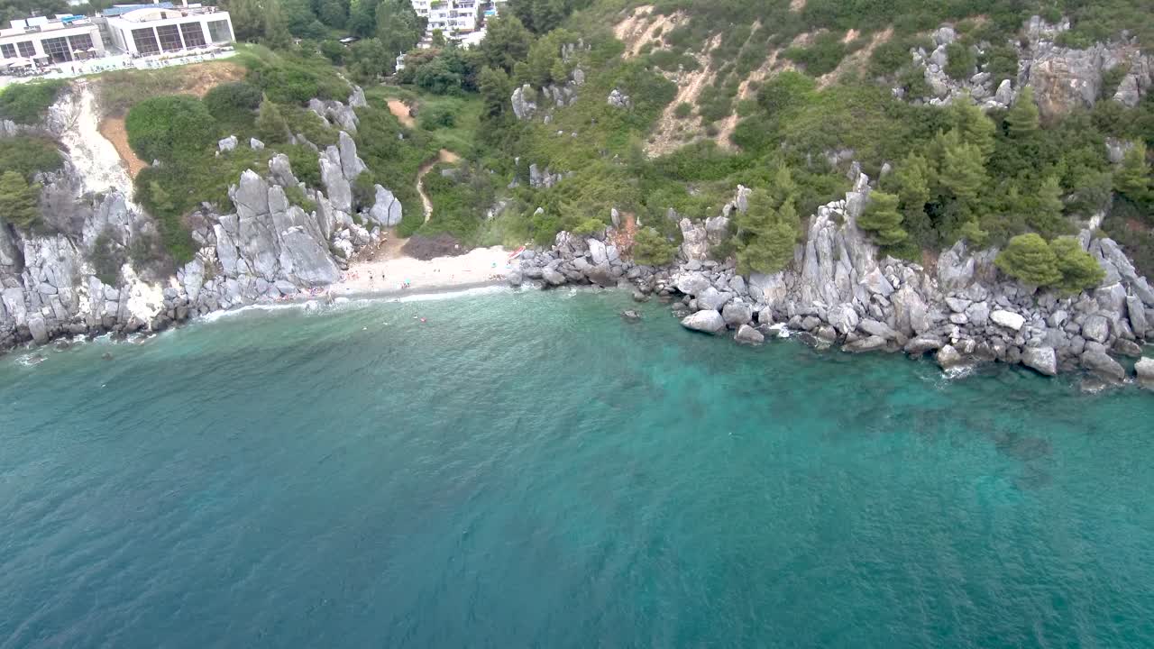 아기아 파라스케비, 할키디키 지역에 있는 온천 건물  ⁇ 에 있는 바위가 있는 작은  ⁇ 로스색 해변의 공중 뷰, 드론으로  ⁇ 으로 이동