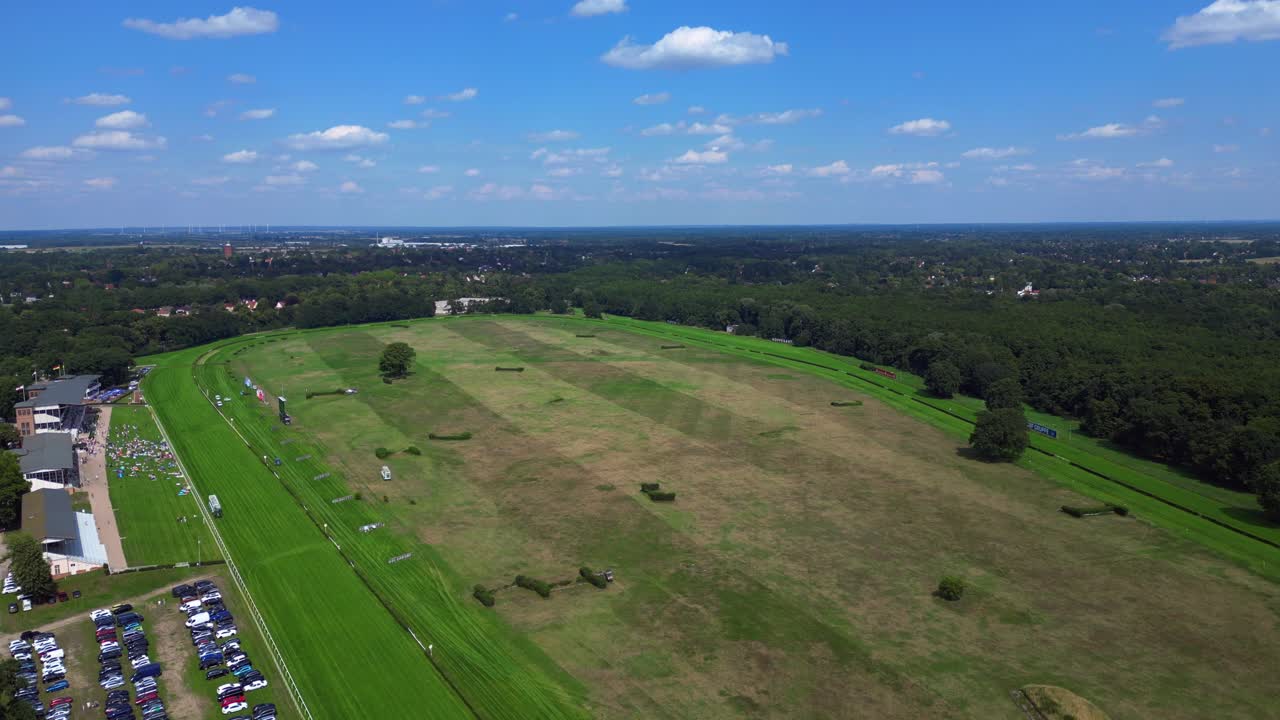 horse racing track with spectators enjoying the competition on a sunny summer day. Nice aerial view flight panorama overview drone