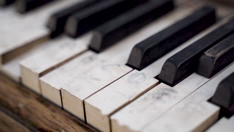 Closeup-of-Old-Broken-Piano-Keys-with-Faded-Notes-on-Them