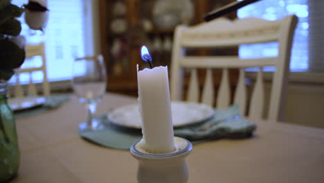 lighting-a-candle-at-a-set-dinner-table