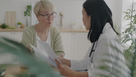 doctor discussing medical records with patient at home