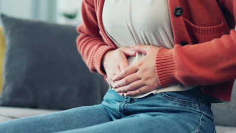 stomach pain, woman hands and living room sofa