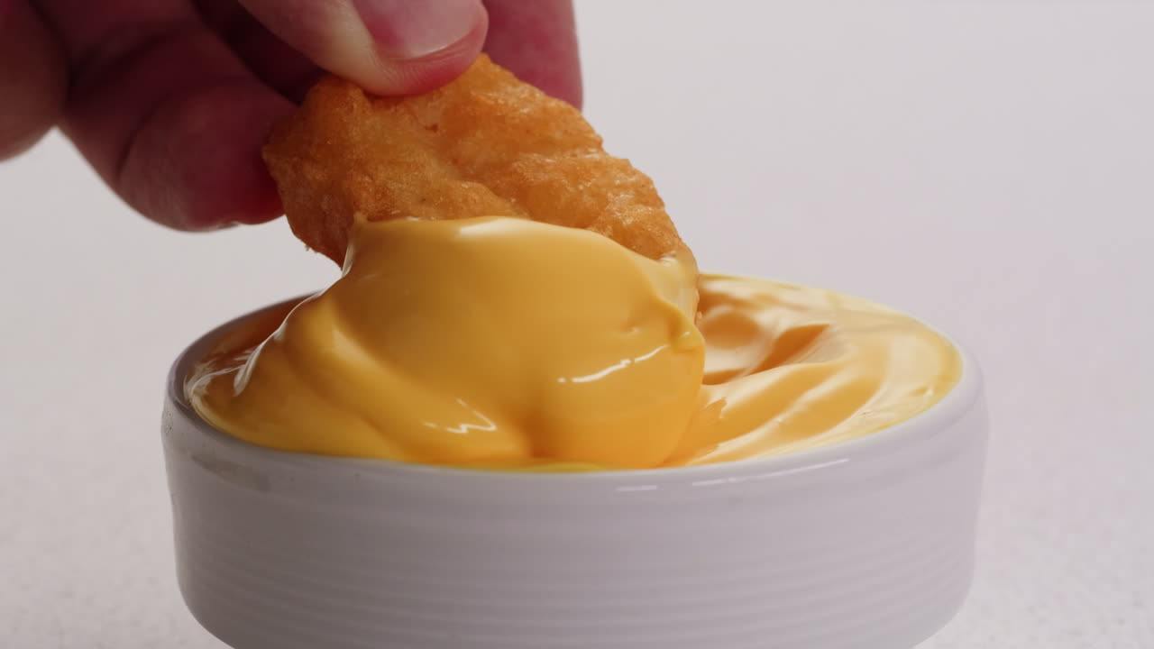 Dipping Chicken Nuggets in Cheese Sauce
