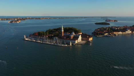 aerial view flying to church of san giorgio maggiore during sunset in venice in italy in 4k