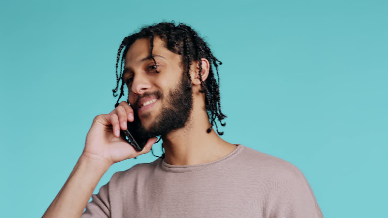 Man discussing with best friend over telephone call using smartphone, studio