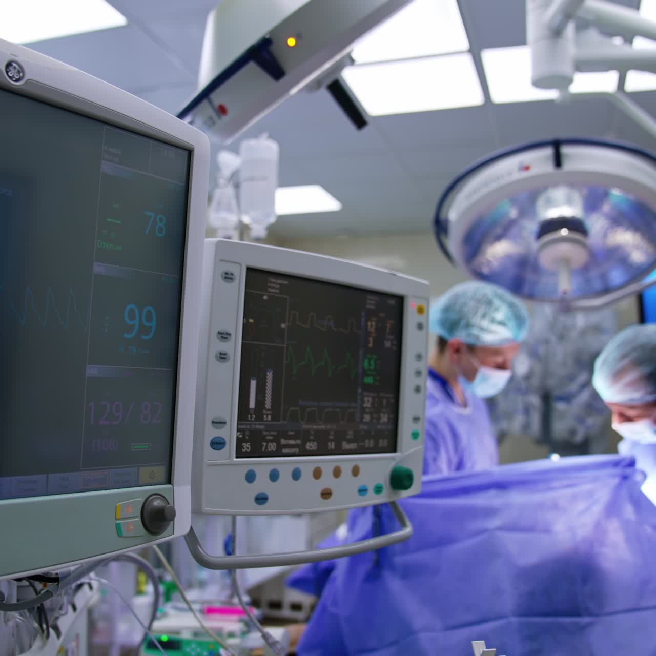 Monitor di apparecchiature moderne al lavoro nella sala operatoria durante l'operazione. Schermi che mostrano i segni vitali di un paziente
