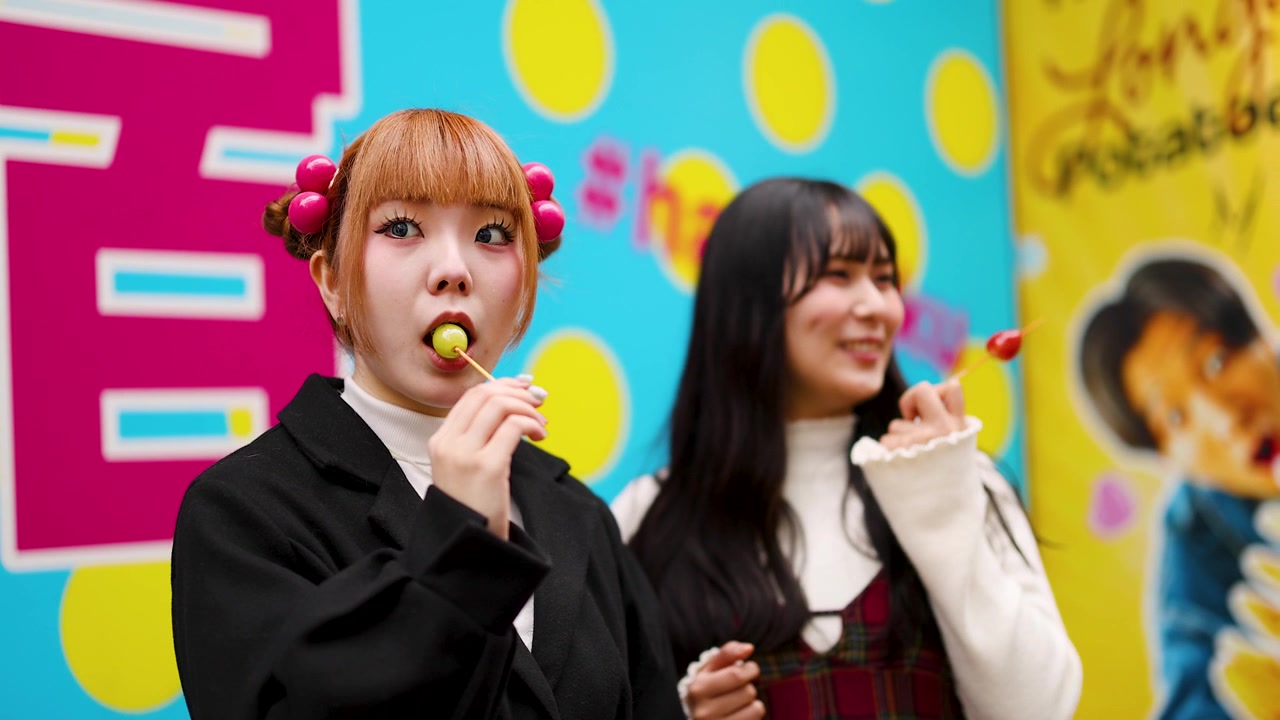 Two Young Women Eating Candy Skewers in Harajuku