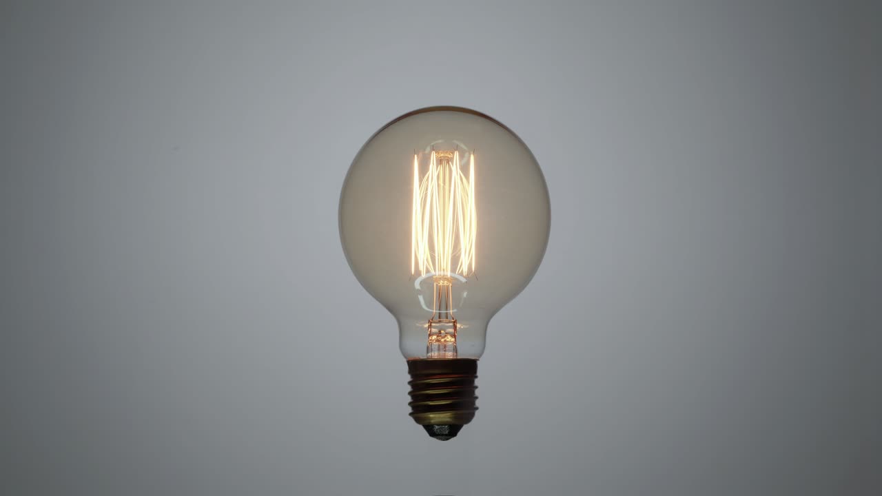 una bombilla de tungsteno parpadeando sobre un fondo blanco.
