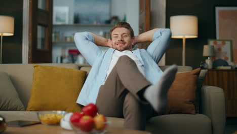 handsome guy chilling couch cozy living room. carefree man relaxing in evening