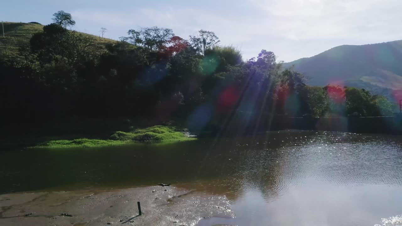 espectáculo aéreo en movimiento sobre el lago con luces solares que revelan el vasto valle del bosque atlántico