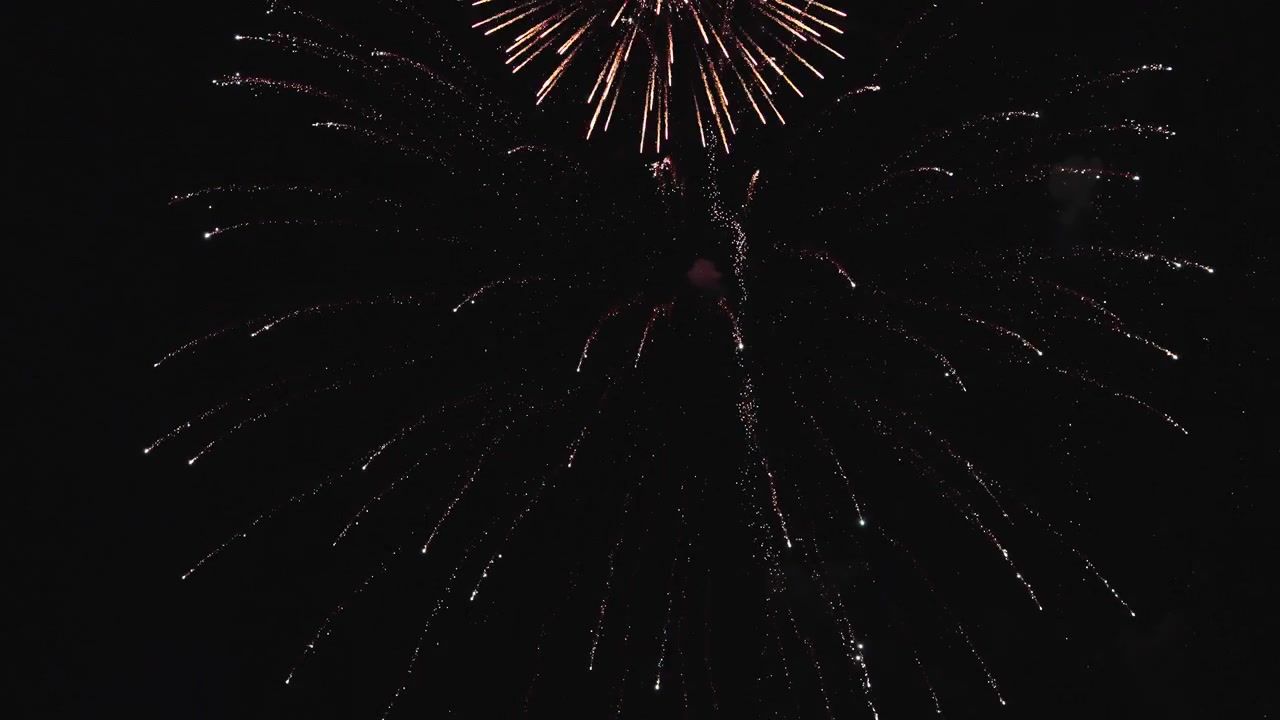 Intense fireworks explosions captured in slow motion against dark sky