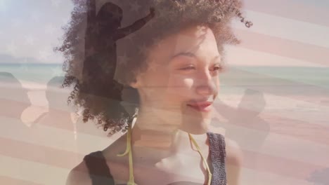 Animation-of-flag-of-united-states-of-america-over-happy-african-american-woman-on-beach