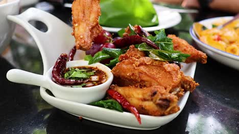 hand serving fried chicken with dipping sauce