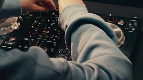 dj with headphones and sunglasses playing music on festival in night club. techno musician performing at nightclub for concert crowd of people, city bar.