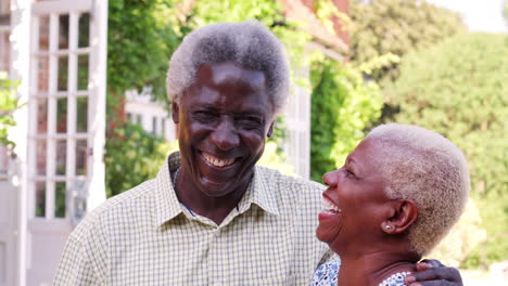 Senior-Pareja-Negra-Abrazándose-Y-Sonriendo-En-Un-Jardín.