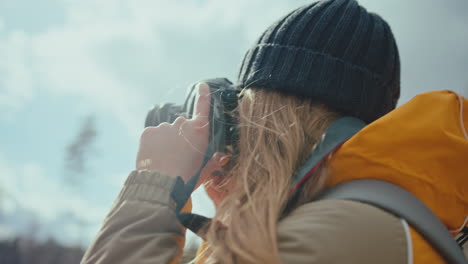 young woman taking pictures with a digital photo camera and reviewing them