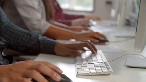 close up of college students using computers in study room