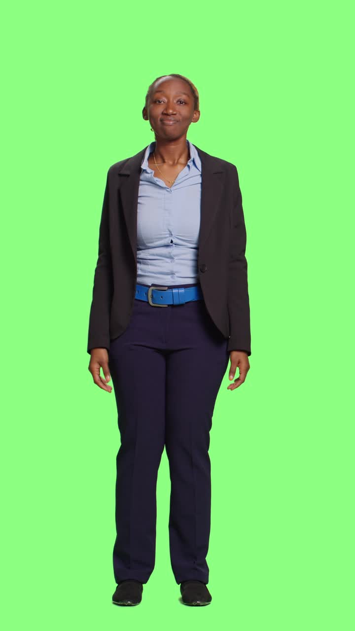 Vertical video: Business woman doing i dont know clueless sign on full body greenscreen