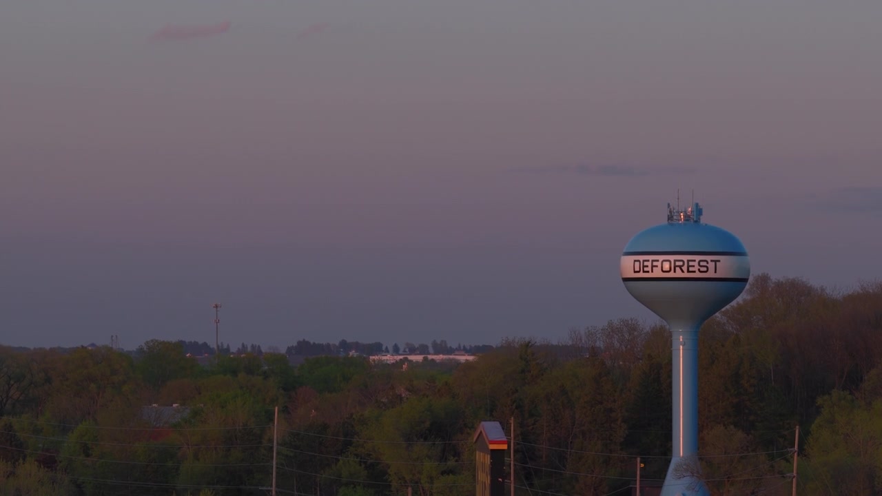 Luftaufnahme bei Dämmerung über dem Wasserturm des Dorfes DeForest, Wisconsin.