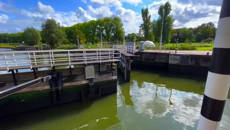 dutch sluice gate doors opening at noordhollandsch kanaal in amsterdam